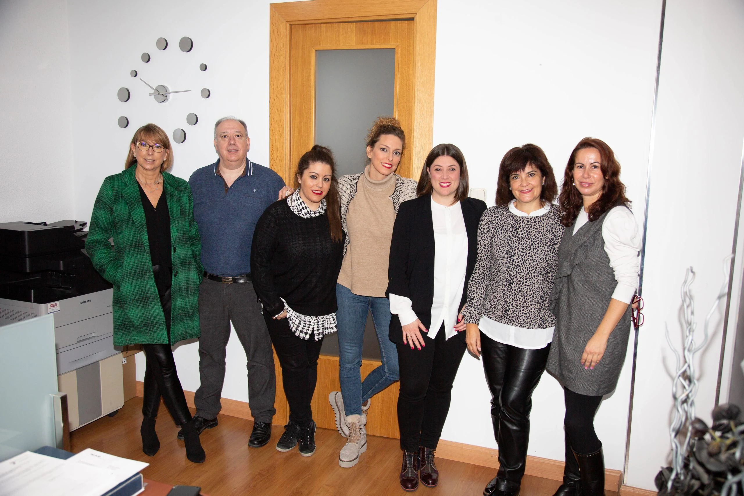 Siete miembros del equipo de asesores en Zaragoza posan juntos y sonrientes en un despacho de la oficina