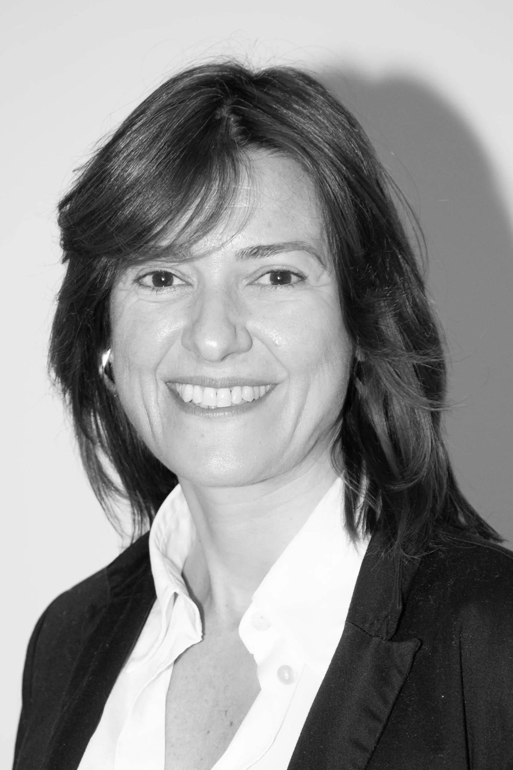 Gestora Zaragoza Retrato en blanco y negro de una mujer sonriente de media melena con americana negra y camisa blanca, gestora en Zaragoza